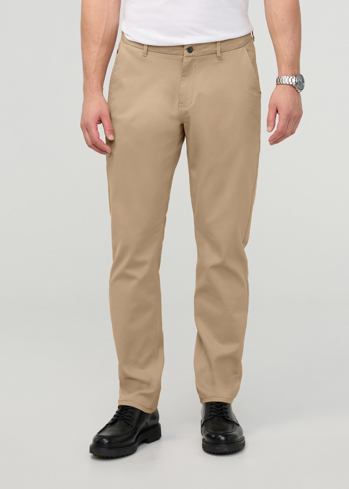 Men's desert khaki relaxed taper trousers with button waistband, worn with white shirt and black shoes.