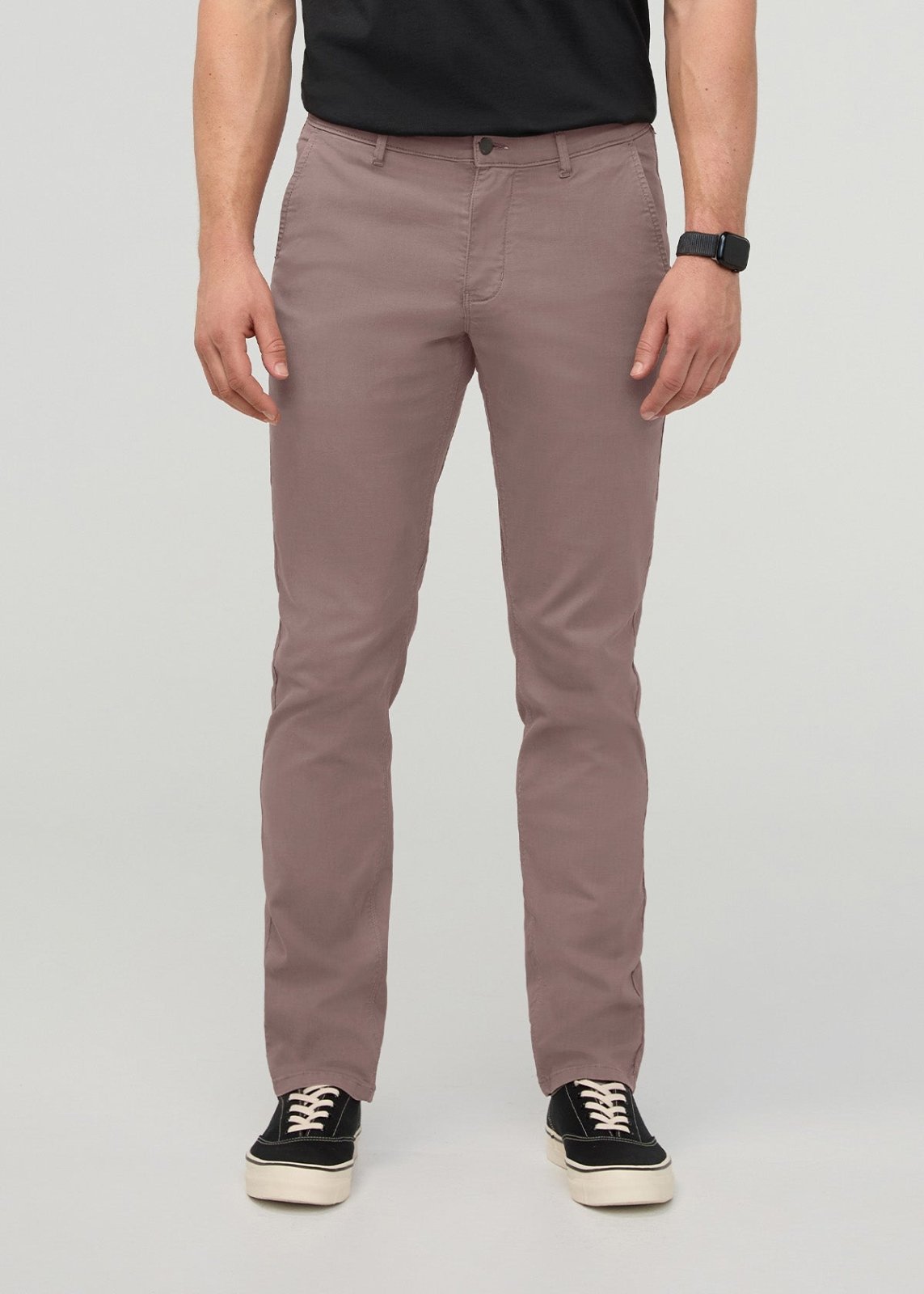 Man wearing hazy mauve slim straight chino pants with black t-shirt and black sneakers.