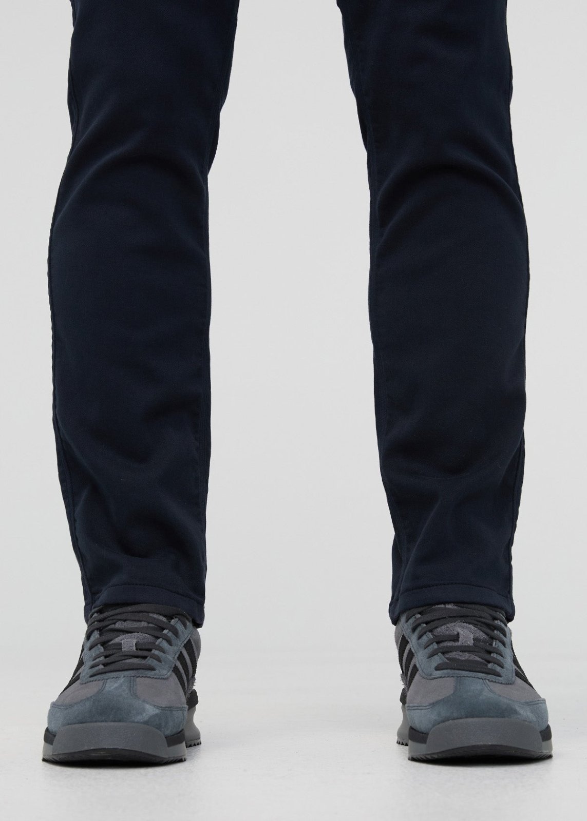 Navy slim straight pants with straight leg opening worn with gray lace-up hiking boots.