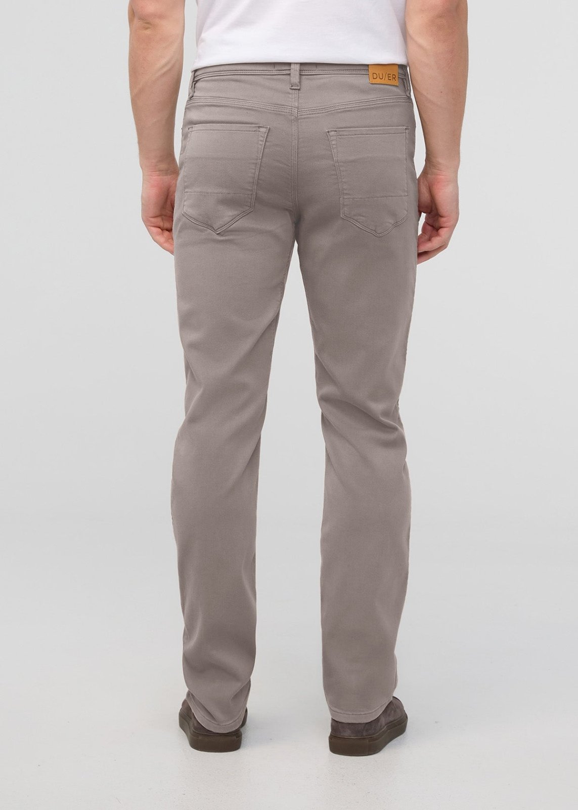 Men's stone-colored straight-leg jeans with tan label at waistband, shown from back view.