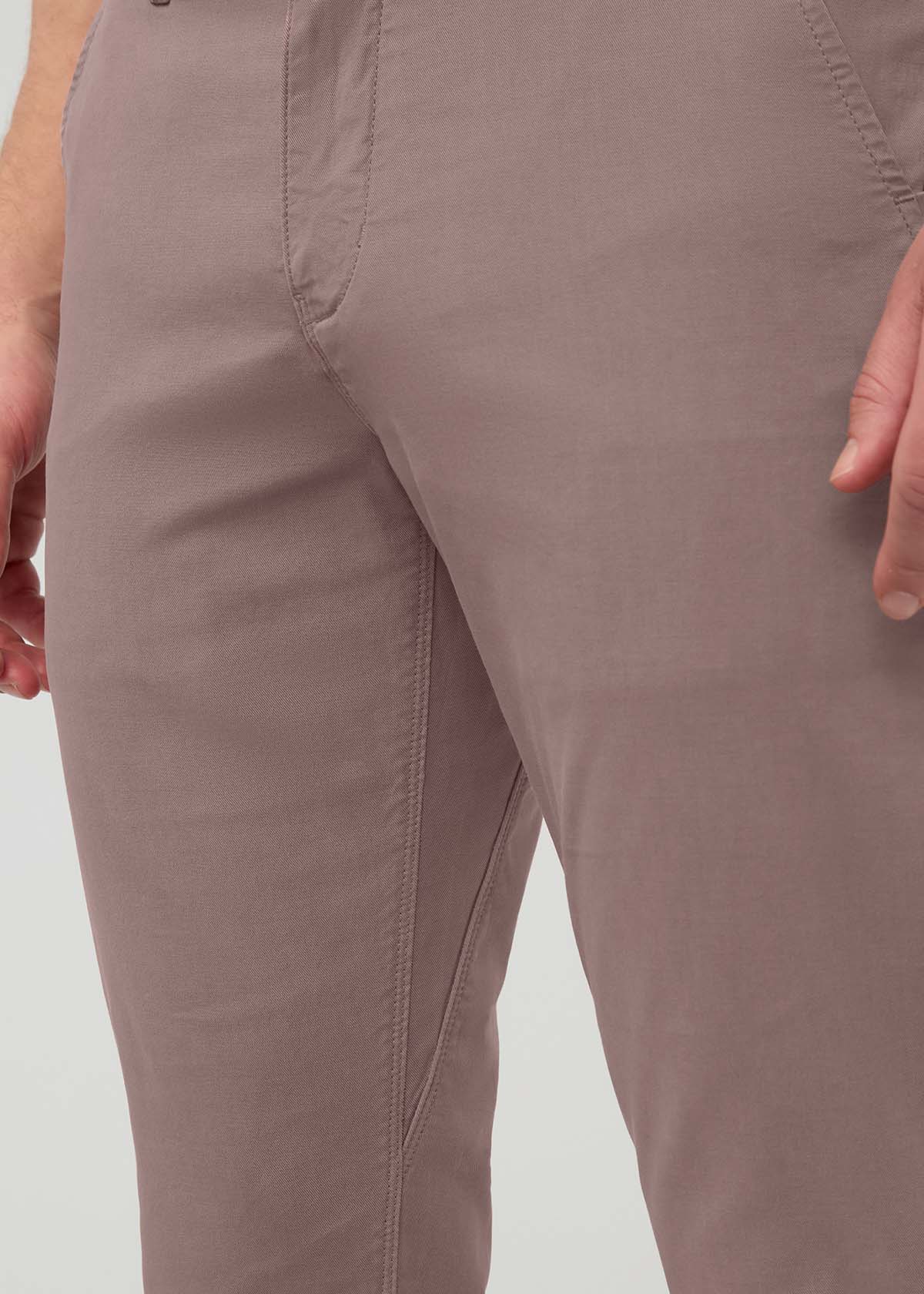 Hazy mauve slim straight chino pants with flat front seams and visible inseam detail on wearer.