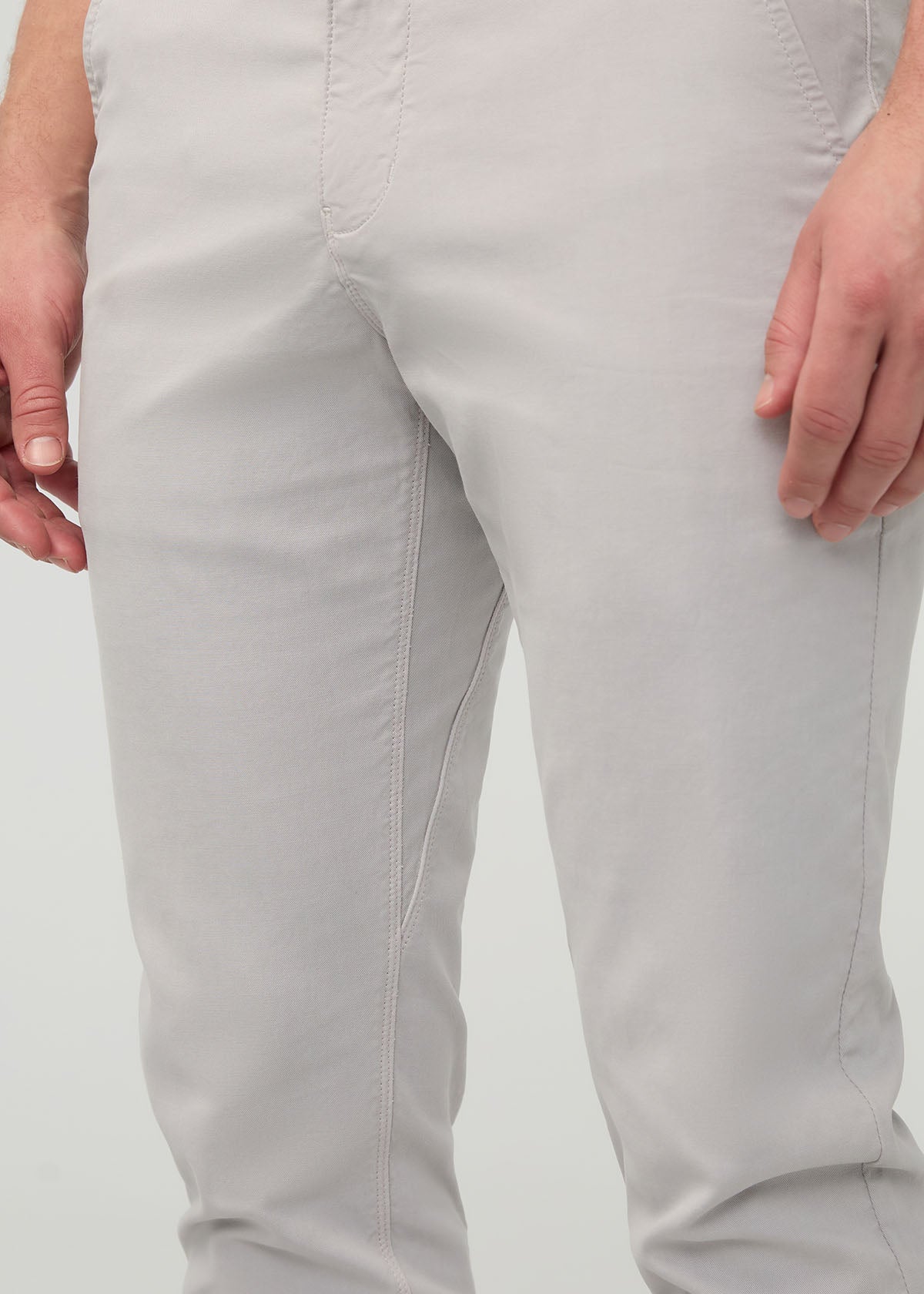 Light gray slim straight chino pants with visible inseam stitching, shown on model from waist to ankle.