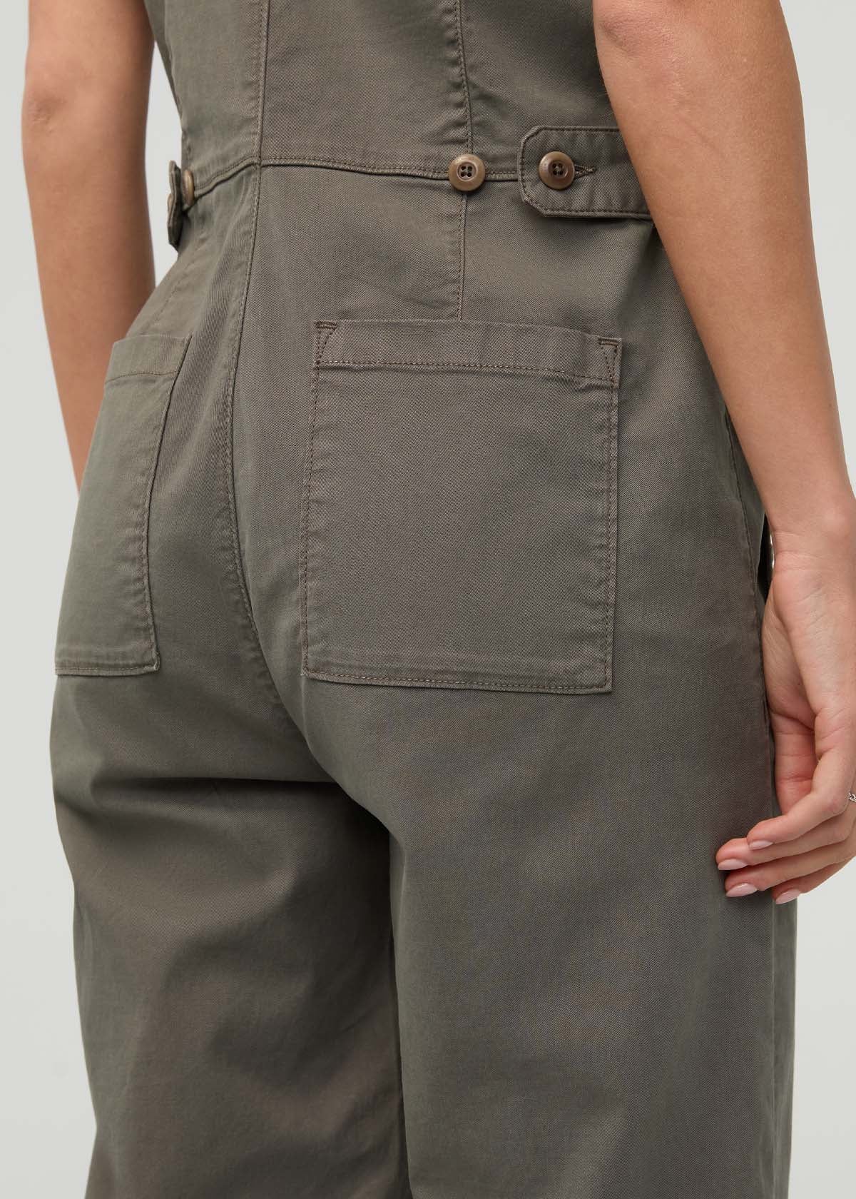 Thyme-colored boiler suit with button-front closure, belt, and cargo pockets shown on model from waist down.