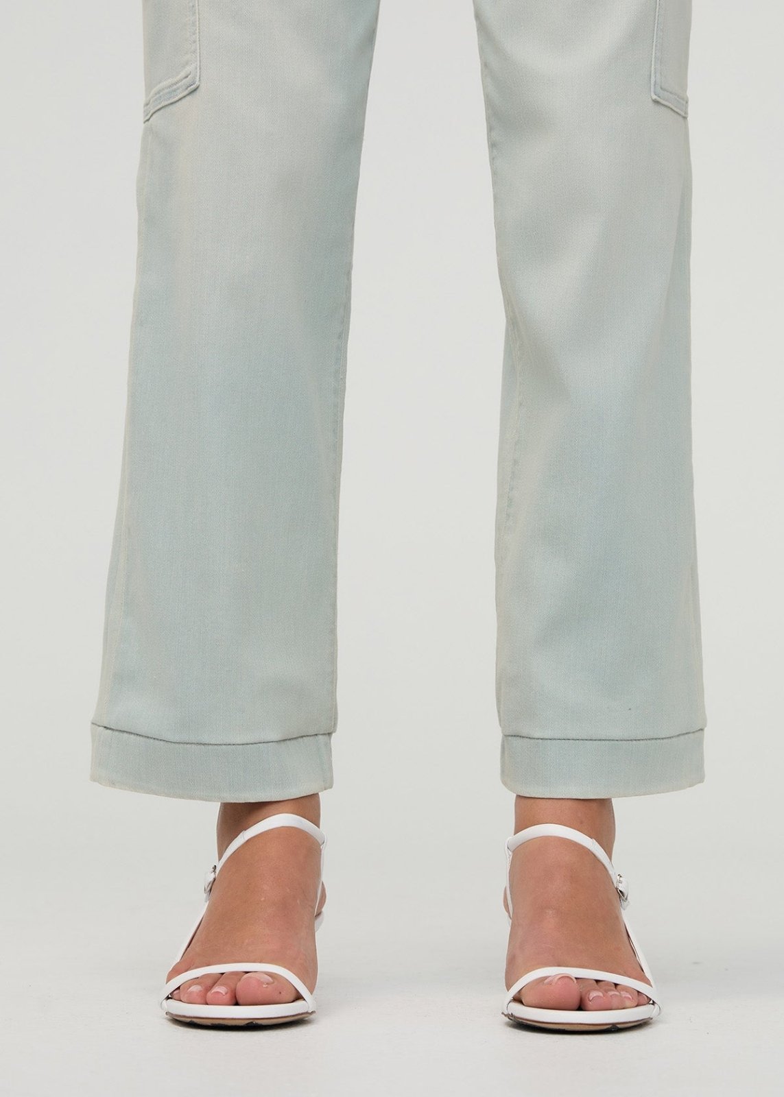 Light gray high-rise cargo pants with side pockets and rolled cuffs, shown from waist down.