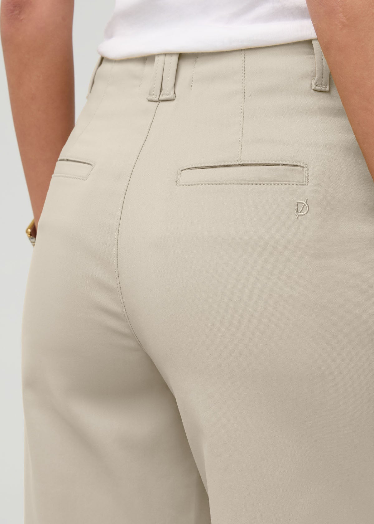 Sandstone high-rise trouser with belt loops, front pockets, and back patch pocket detail on model.